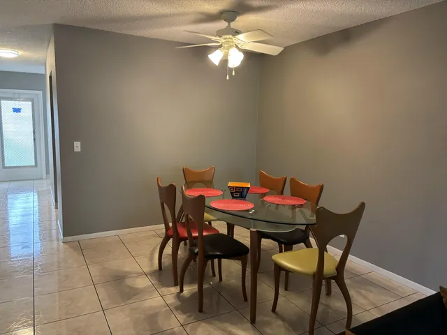 a view of a dining room with furniture and chandelier fan