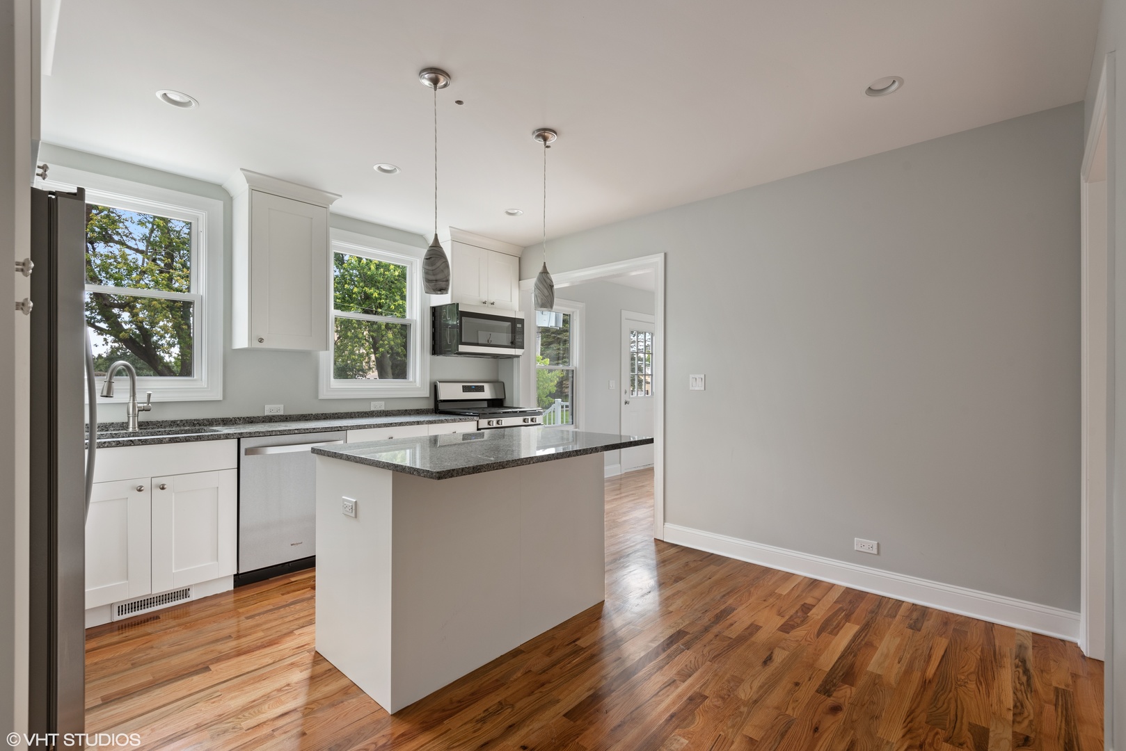 1131 Ridge Road, Unit 1 Wilmette, IL 60091 - Photo 7 of 14 a kitchen with stainless steel appliances granite countertop a sink a stove a refrigerator and island with wooden floor