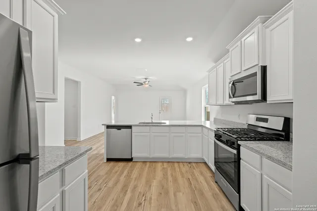 a kitchen with a refrigerator stove top oven and sink
