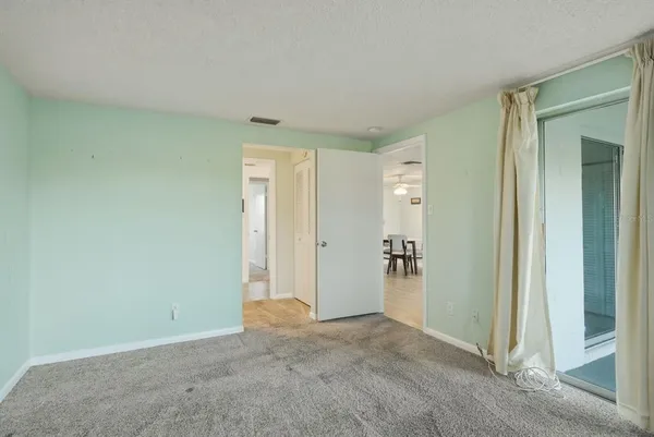 an empty room with closet and a hallway