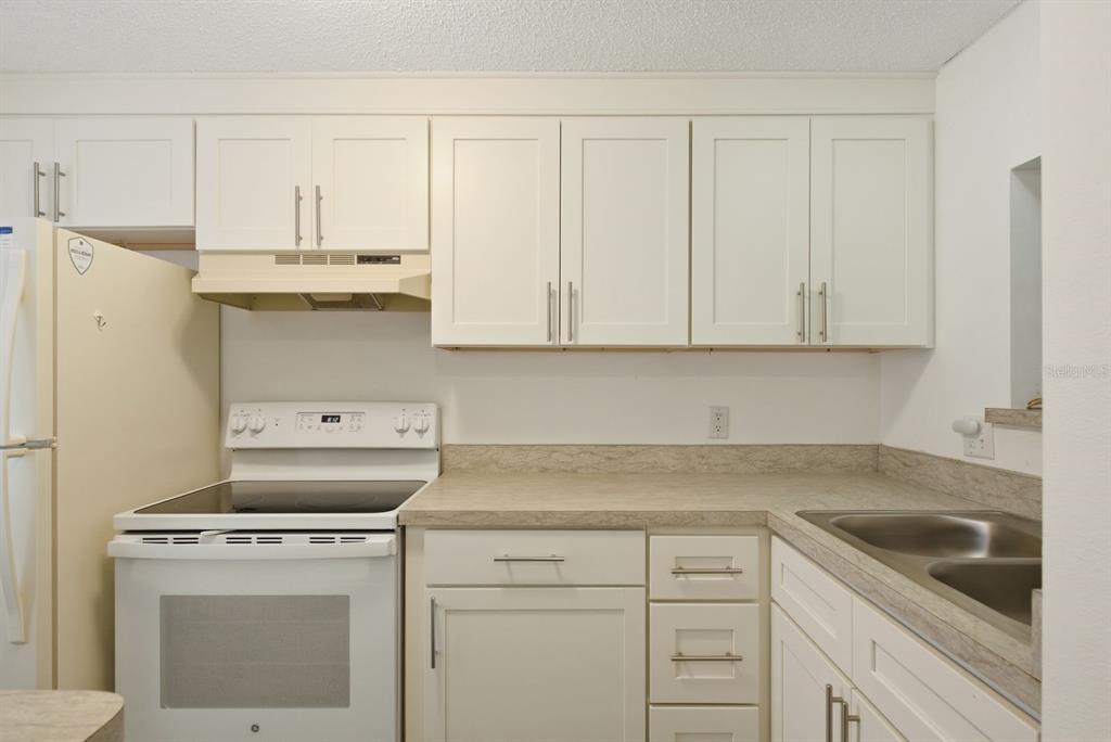 3309 Trophy Boulevard New Port Richey, FL 34655 - Photo 4 of 37 a kitchen with granite countertop white cabinets and white appliances