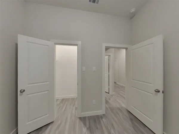 a view of a hallway with wooden floor