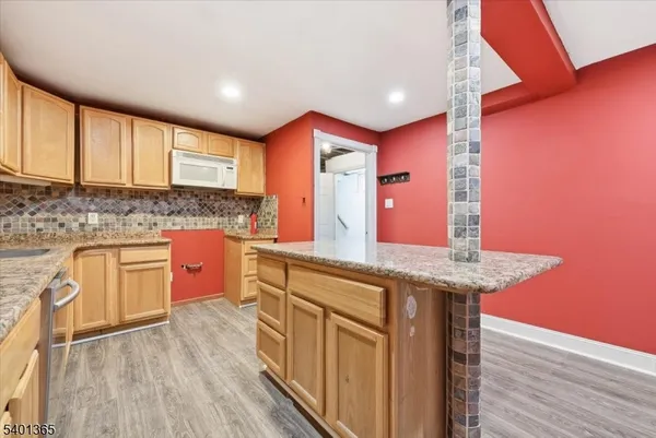 a kitchen with stainless steel appliances granite countertop a sink a stove and wooden floor