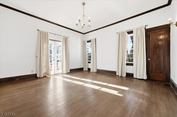 an empty room with window and wooden floor