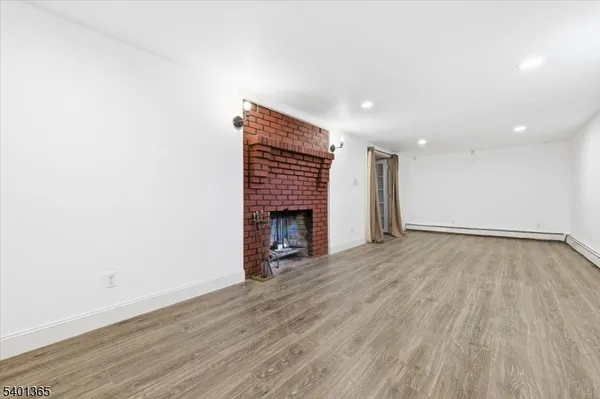 an empty room with wooden floor and fireplace