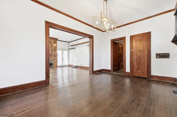 a view of a hallway with wooden floor and chandelier