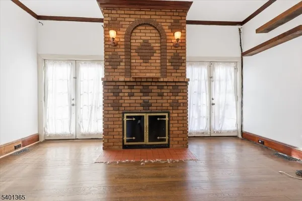 a view of empty room with wooden floor and fireplace