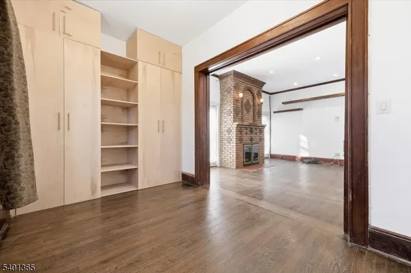 a view of empty room with wooden floor and windows