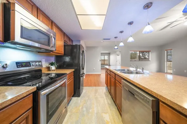 a large kitchen with stainless steel appliances granite countertop a stove and a sink