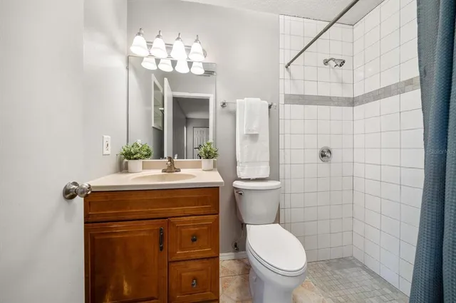 a bathroom with a granite countertop toilet sink and mirror