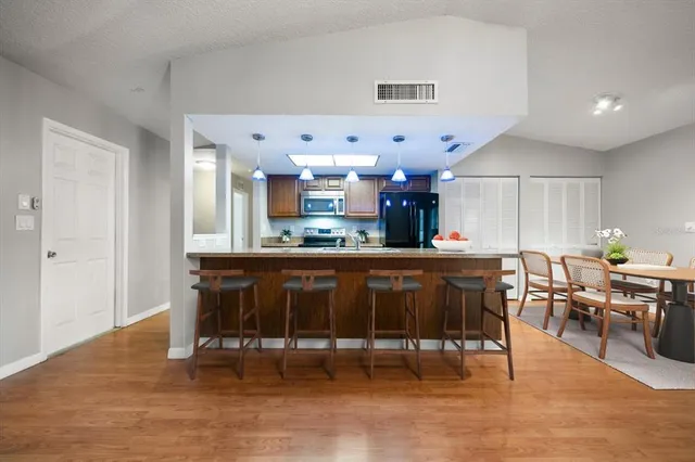 a living room with stainless steel appliances kitchen island granite countertop furniture and a dining table