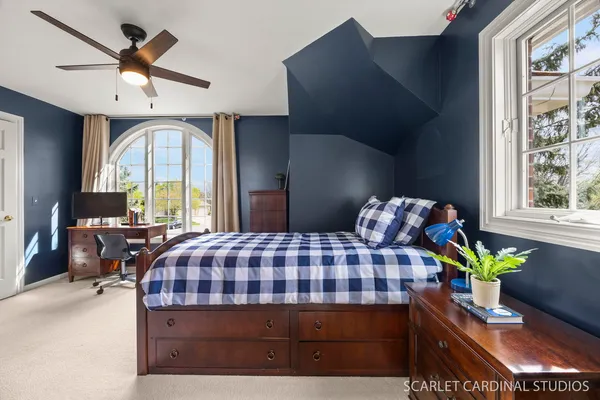 a spacious bedroom with a large bed and a chandelier