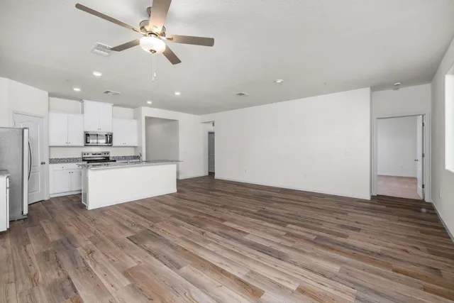 a view of kitchen with granite countertop cabinets and refrigerator