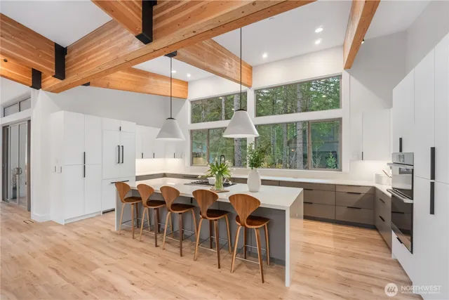 a large dining hall with stainless steel appliances granite countertop a stove and a dining table with the kitchen view