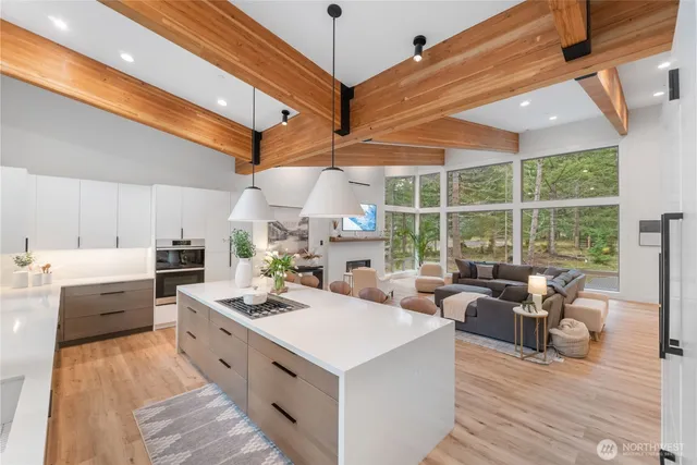 a large white room with stainless steel appliances kitchen island granite countertop furniture and a large window