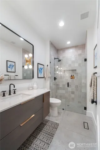 a bathroom with a sink a toilet and shower