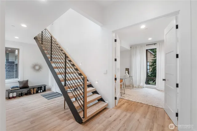 a view of a hallway with wooden floor and staircase