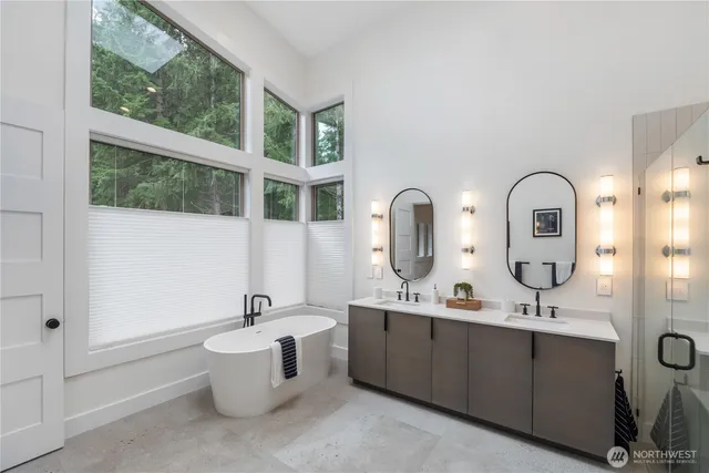 a bathroom with a double vanity sink a mirror and a bathtub