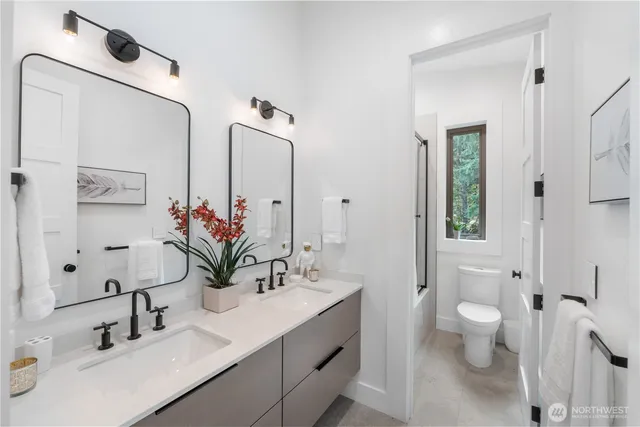 a bathroom with a double vanity sink toilet and shower