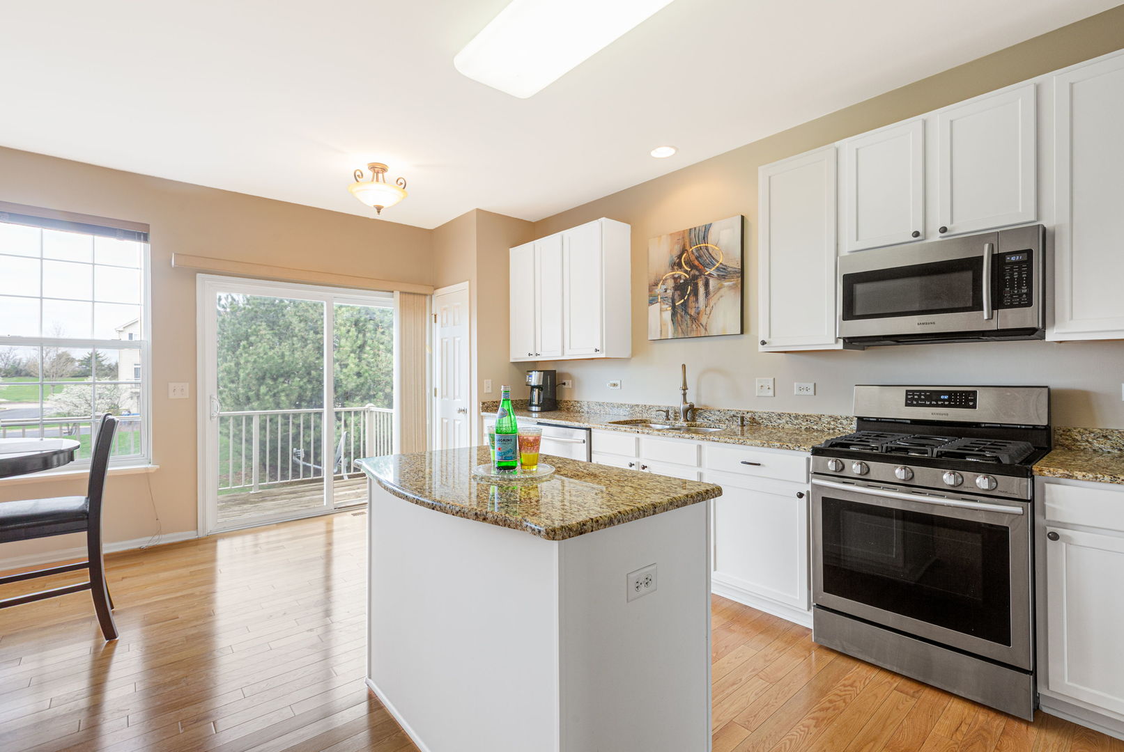 674 Lambert Lane Bartlett, IL 60103 - Photo 6 of 22 a kitchen with stainless steel appliances granite countertop a stove a sink and a microwave