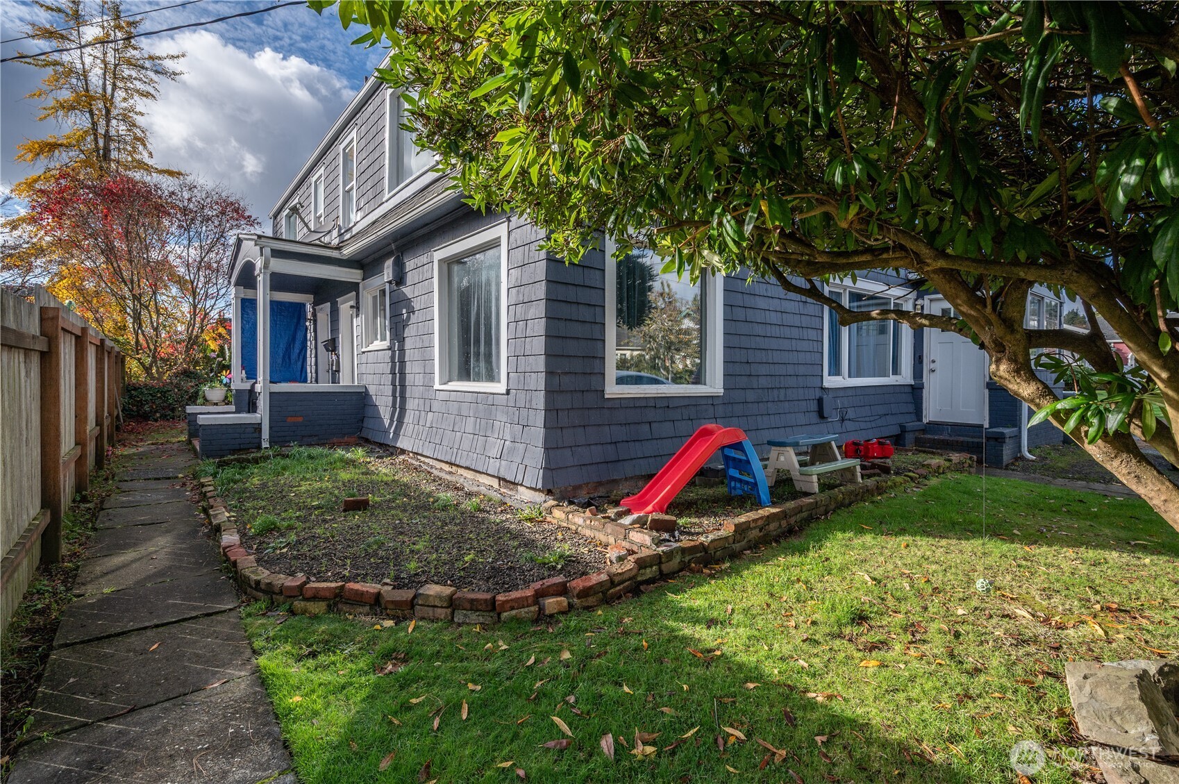 a view of house with a yard and potted plants