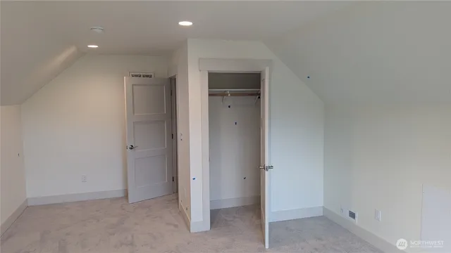 an empty room with closet and wooden door