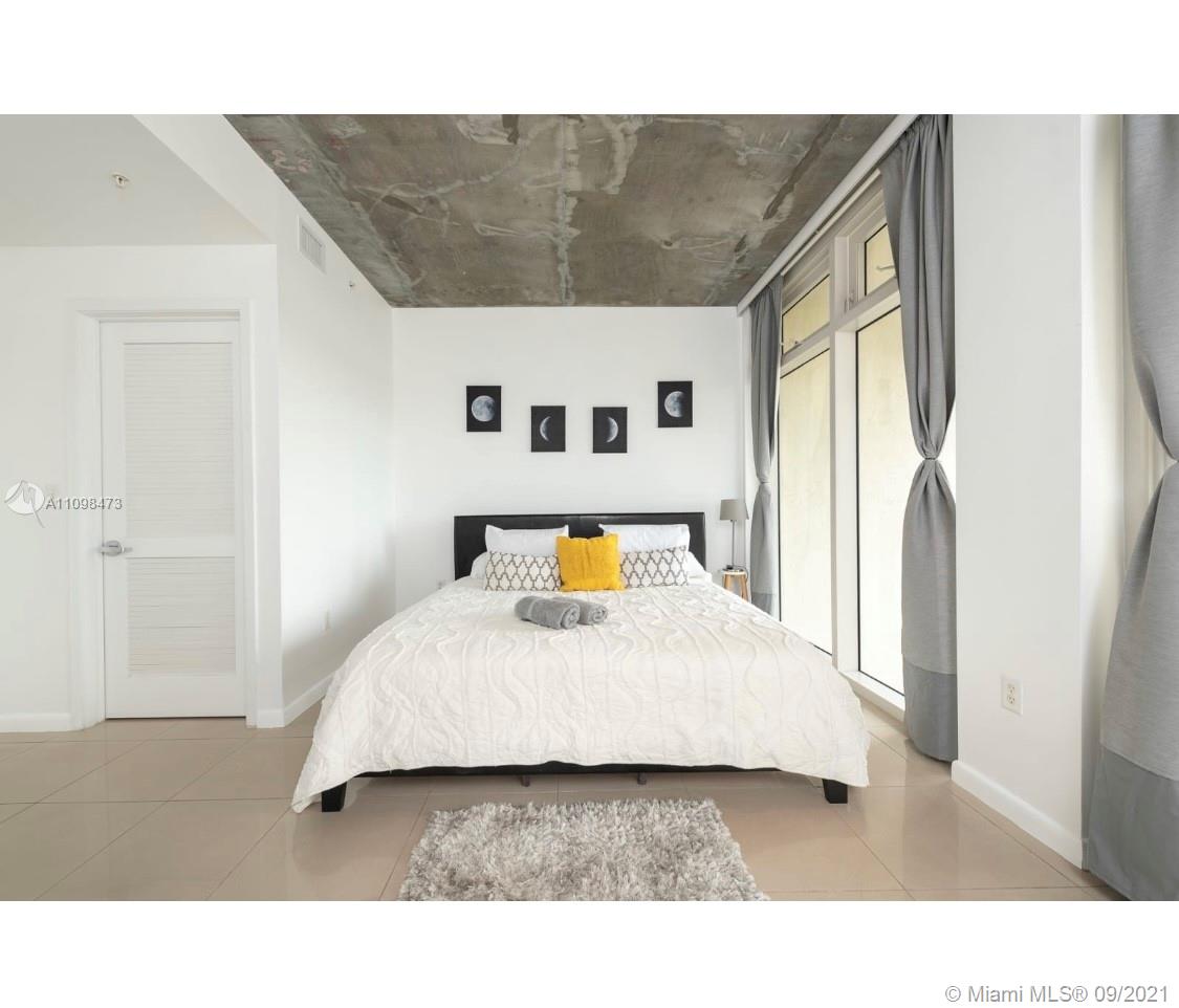 Midtown Miami Miami, FL 33127 - Photo 9 of 26 a living room with a bed and dresser with wooden floor