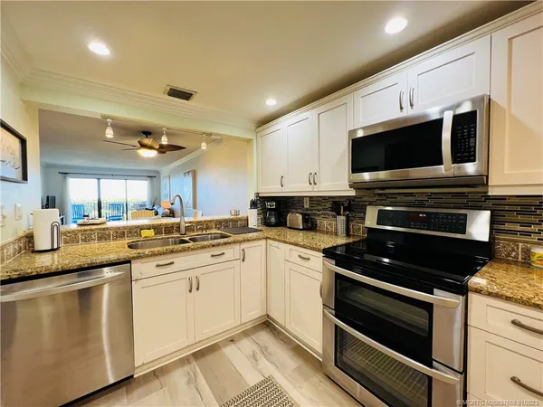 a kitchen with stainless steel appliances granite countertop a stove and a sink