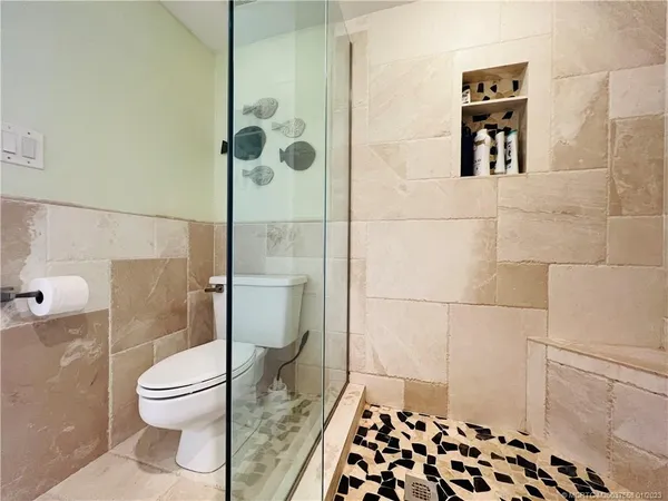 a bathroom with a granite countertop toilet sink and mirror