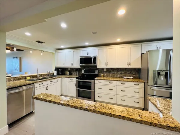 a kitchen with granite countertop stainless steel appliances and cabinets