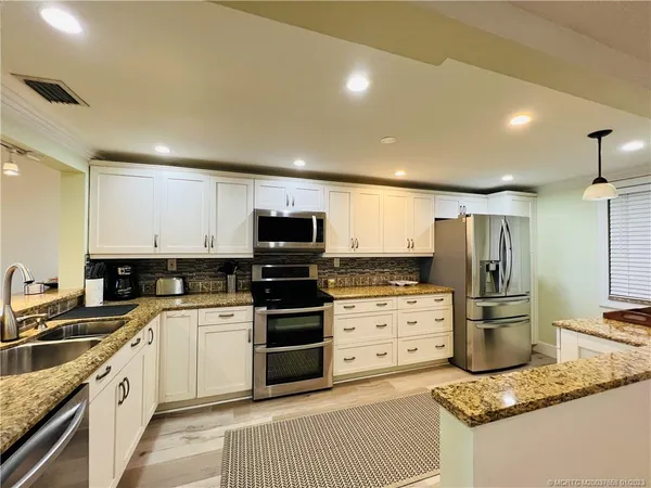 a kitchen with a sink stove and refrigerator