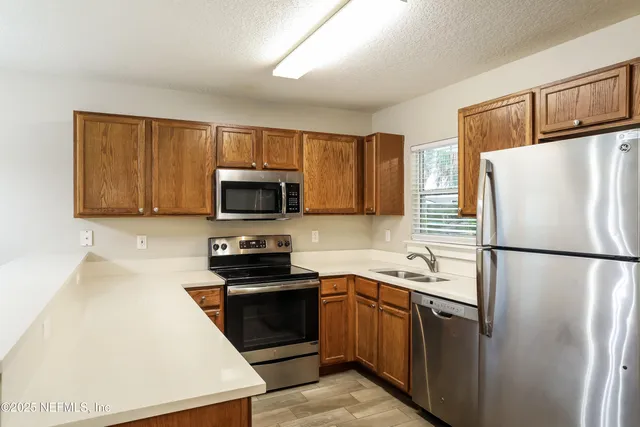 a kitchen with stainless steel appliances a refrigerator stove microwave and sink