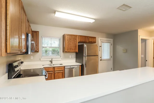 a kitchen with stainless steel appliances a refrigerator and a sink