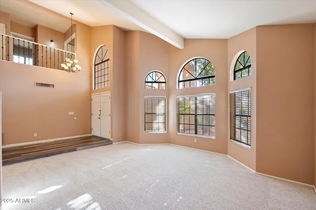 a view of an empty room with window and fire place