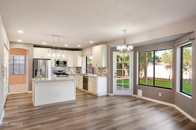 an empty room with windows and ceiling fan