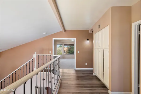 a view of a hallway with wooden floor and staircase