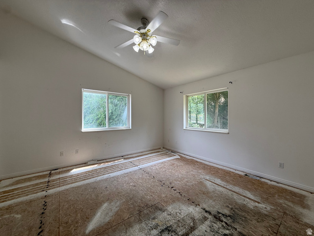 838 East Mountain Road Logan, UT 84321 - Photo 16 of 37 Vaulted ceiling room featuring two windows, a ceiling fan with light fixture, white walls, and subfloor