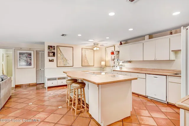 a kitchen with a sink a stove a refrigerator and white cabinets