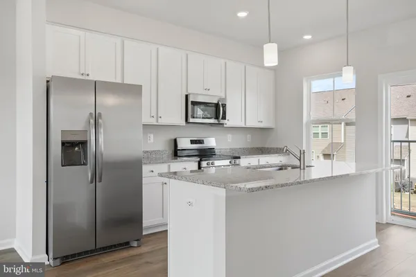 a kitchen with appliances a sink cabinets and wooden floor