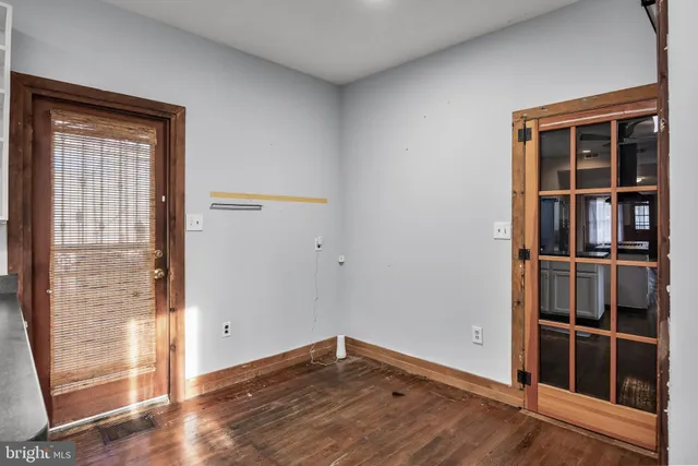 a view of empty room with wooden floor and windows
