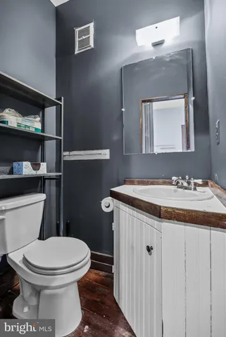 a bathroom with a granite countertop toilet sink and mirror