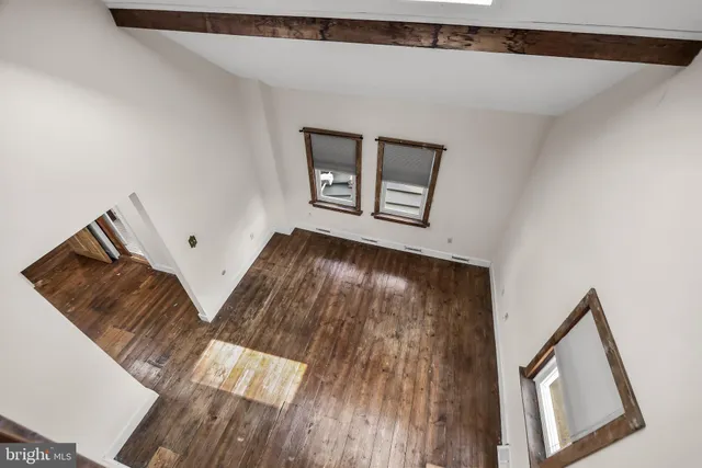a view of a hallway with wooden floor and stairs