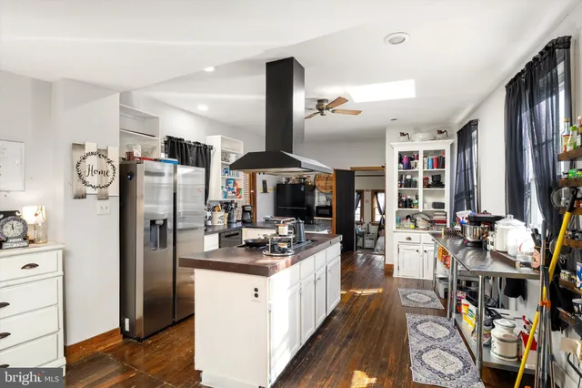 a kitchen with stainless steel appliances kitchen island granite countertop a refrigerator stove and sink