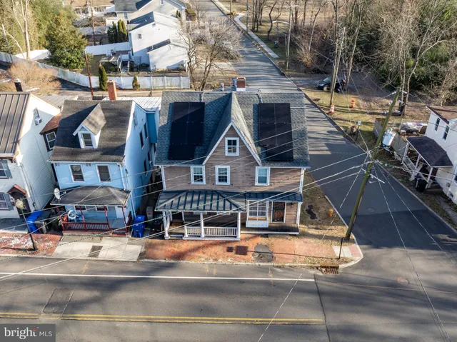a view of a big building with a small yard and large trees
