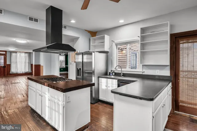 a kitchen that has a sink a stove and a table