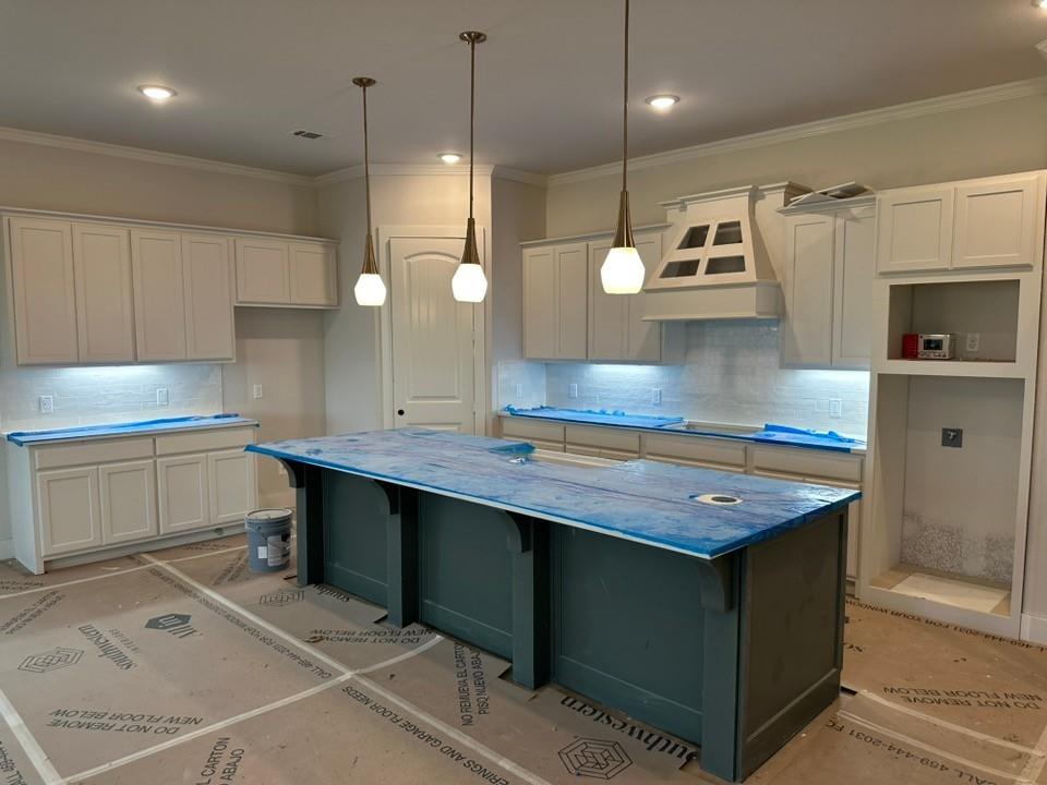 585 Brown Road Leonard, TX 75452 - Photo 10 of 29 Spacious kitchen featuring a large central island with pendant lighting, perimeter cabinetry with under-cabinet lighting, a decorative range hood, and a built-in appliance cavity