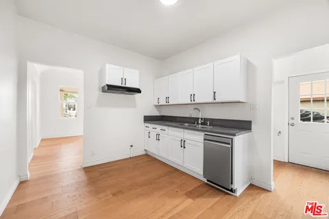 a kitchen with granite countertop white cabinets and white appliances