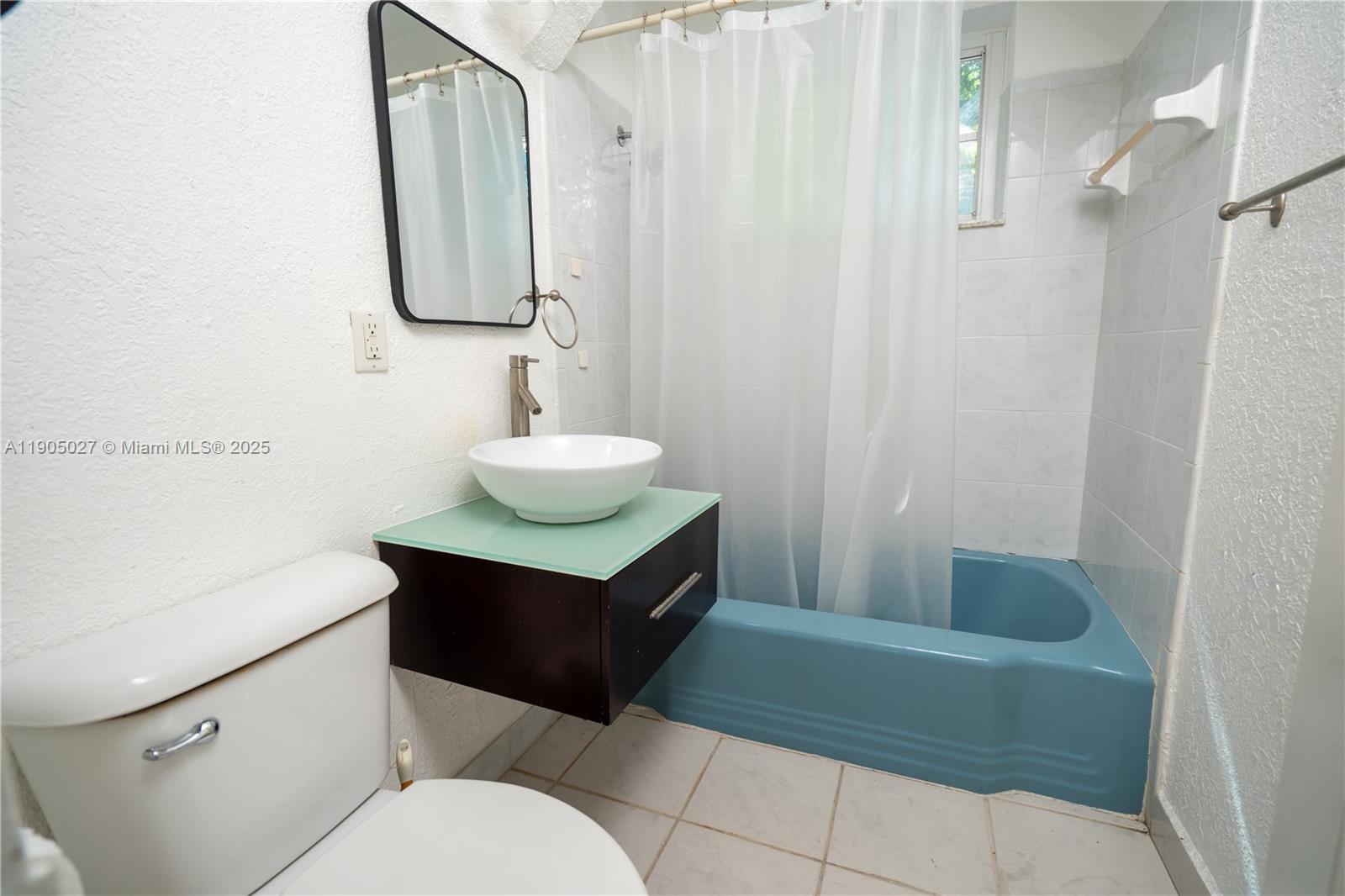 7435 Harding Avenue, Unit 204A Miami Beach, FL 33141 - Photo 7 of 14 a bathroom with a sink vanity mirror and toilet
