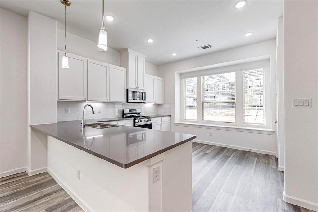 376 Buck Ridge Drive Frisco, TX 75068 - Photo 11 of 40 a kitchen with stainless steel appliances granite countertop a sink stove and wooden floor