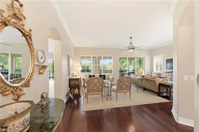 a living room with furniture a large window and wooden floor